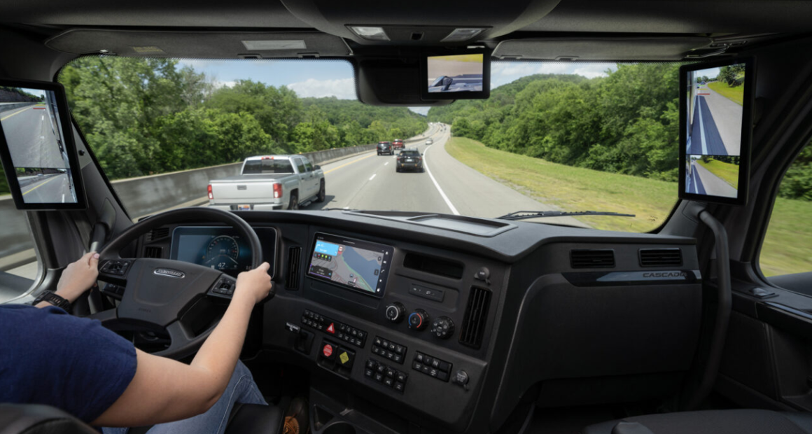 Freightliner truck dashboard and windshield view showing highway driving perspective and digital controls