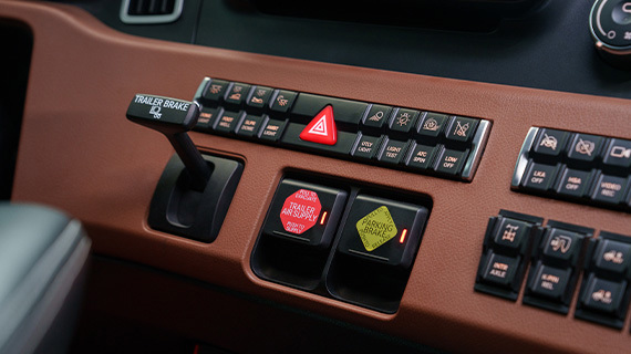 Interior control panel of commercial truck showing hazard controls and dashboard switches with terracotta trim